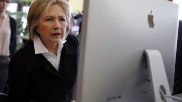 U.S. Democratic presidential candidate Hillary Clinton looks at a computer screen during a campaign stop at Atomic Object company in Grand Rapids, Michigan, U.S. March 7, 2016. REUTERS/Carlos Barria/File Photo